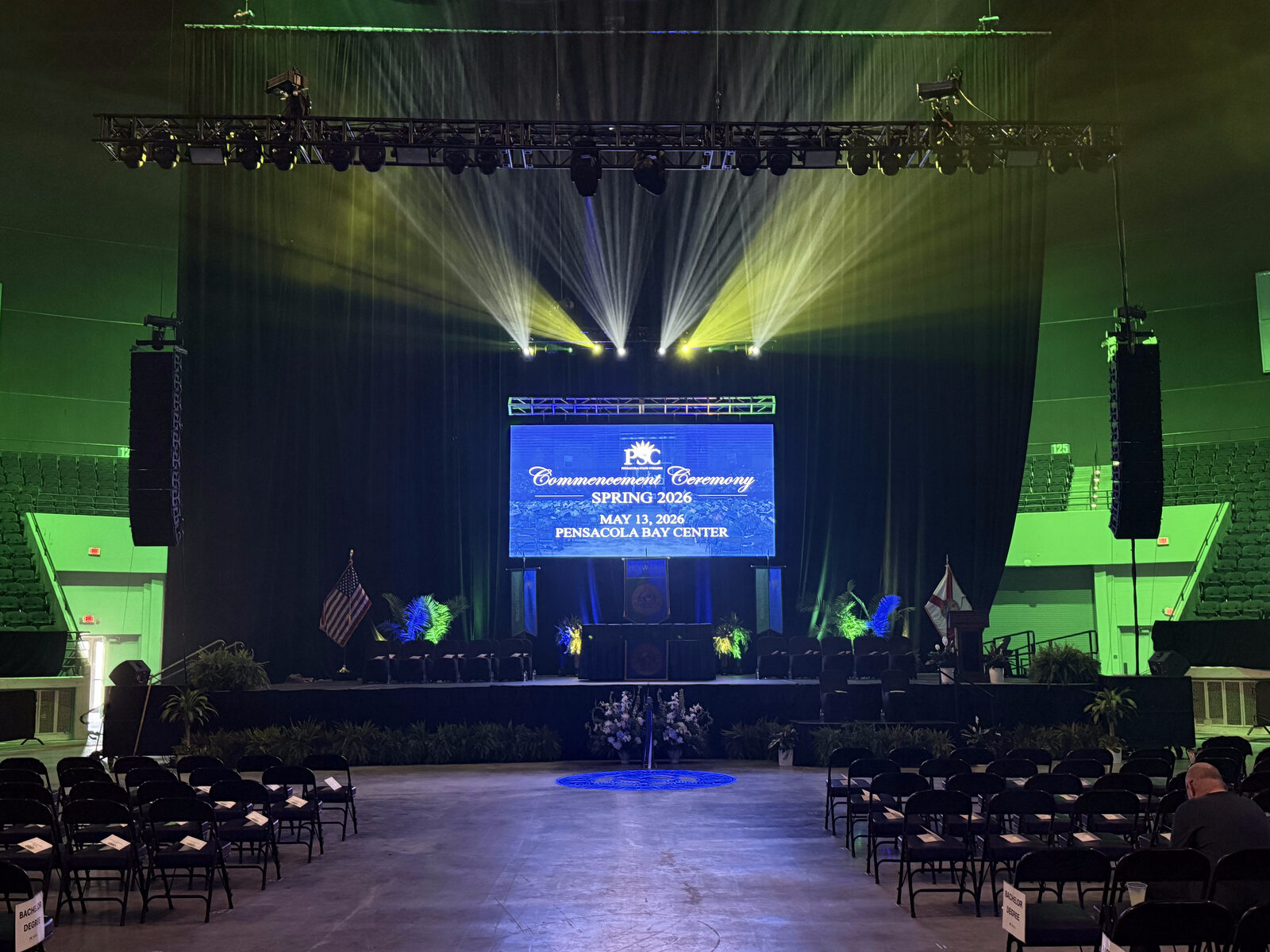 Corporate event setup with stage, lighting, and large video screen